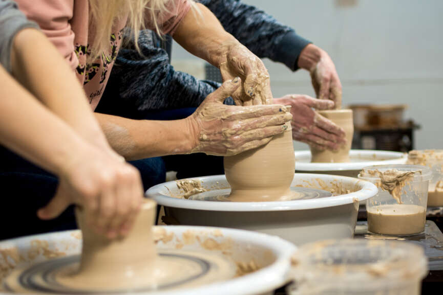 3 students practicing pottery making and learning the basics