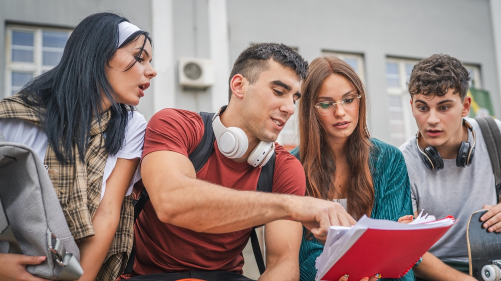 group of teenage students gen z study in front of school university male and female friends caucasian man and woman teenagers prepare exam in front of campus read learn back to school concept