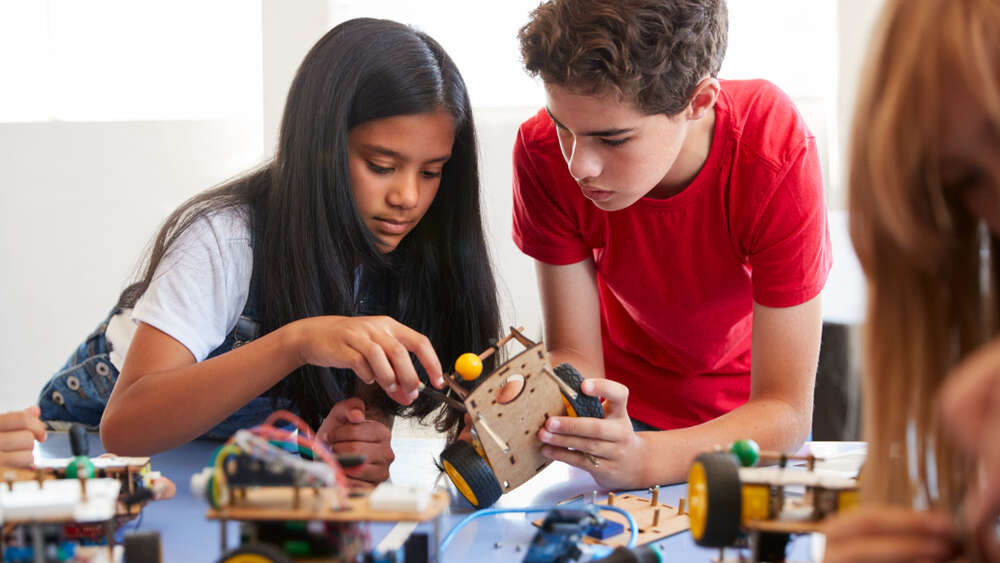 A girl and a boy working on a science project together representing project-based activity and learning