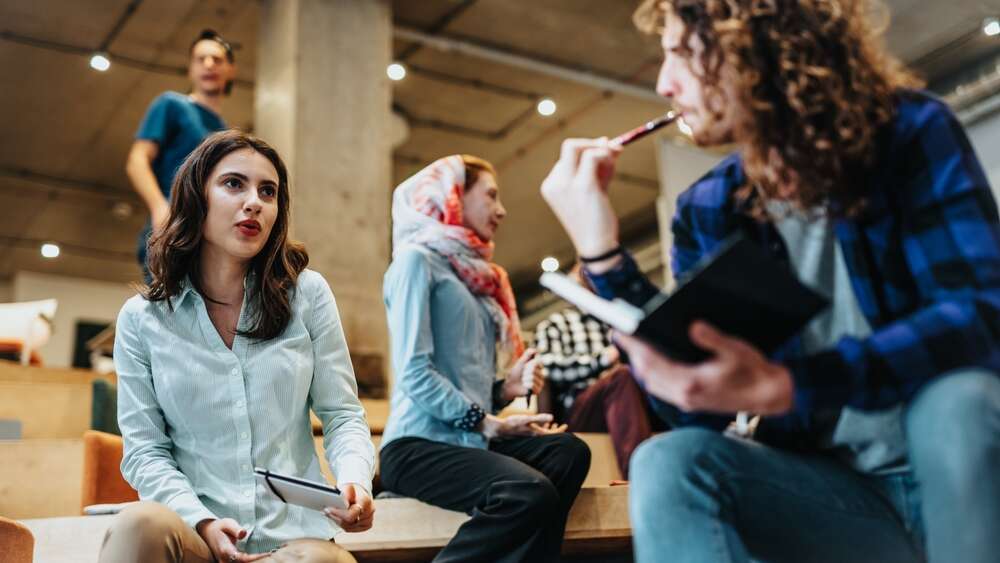 Two young students having a conversation representing the concept of competency-based education